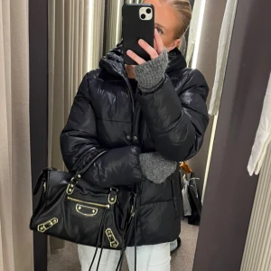 Pufferjacka - Säljer en snygg mörkblå/svart pufferjacka som är perfekt nu till vintern. Jackan har en glansig yta, långärmad och med både dragkedja och knappar framtill. Den är både varm och stilren🩷intressekoll så är inte helt säker på om jag vill sälja än