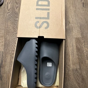 Yeezy slide  - Oanvända tofflor är i nya skick samt jätte sköna att gå med säljer pågrund av att jag köpte två tofflor men gillade inte färgen på båda kan vara öppen med utbyten ifall ni har färgen vit eller svart 