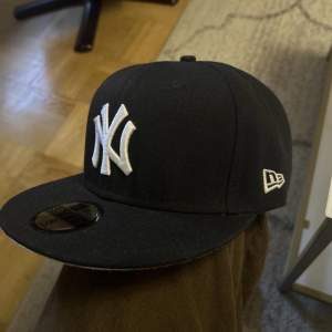 Svart New York Yankees keps med snygg patch i sidan på statue of liberty.  Storlek 8 (63.5cm) Har endast testats hemma, aldrig använd ”ute”. Nypris över 500 kr.  Säljer eftersom den ej passar mitt huvud.