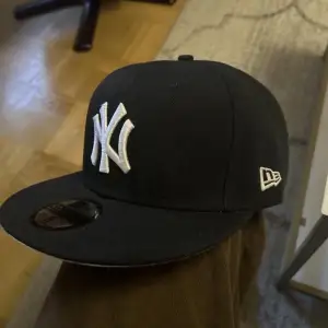 Svart New York Yankees keps med snygg patch i sidan på statue of liberty.  Storlek 8 (63.5cm) Har endast testats hemma, aldrig använd ”ute”. Nypris över 500 kr.  Säljer eftersom den ej passar mitt huvud.