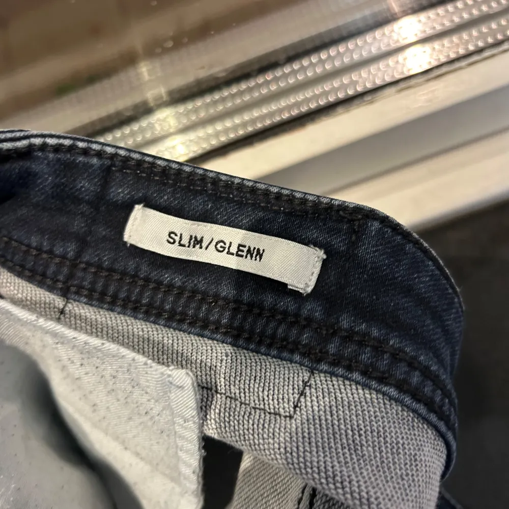 Säljer ett par snygga mörkblå slim jeans från Jack & Jones i modellen Glenn. De är i bra skick och perfekta för både vardag och fest. Jeansen har en klassisk femficksdesign och är tillverkade i ett stretchigt material för extra komfort. Passar perfekt till en t-shirt eller skjorta!. Jeans & Byxor.