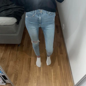 Ljusa jeans med slitningar - Säljer ett par ljusa jeans med snygga slitningar. De är högmidjade och har en tight passform som sitter perfekt. Skinny super high Waits från stradivarius. 