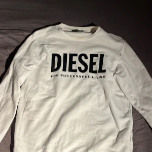Vit långärmad tröja från Diesel - Säljer en snygg vit långärmad tröja från Diesel i storlek S. Tröjan har en cool logga på framsidan och är perfekt för både vardag och chill. Den är i mycket bra skick och superbekväm att ha på sig. Passar perfekt till jeans eller joggers!