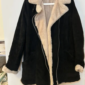 Svart mockajacka med foder från Jofama - Säljer en snygg svart mockajacka från Jofama i storlek 46. Jackan har ett mysigt beige foder som syns vid kragen och ärmsluten. Den har en dragkedja framtill och två fickor. Perfekt för kyliga höst- och vinterdagar. 🖤 nypris 3500 kr mitt pris 1500kr.