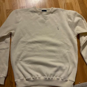 Vit tröja från Polo Ralph Lauren - Säljer en stilren vit tröja från Polo Ralph Lauren i mycket bra skick. Skriv för frågor eller fler bilder. M/L
