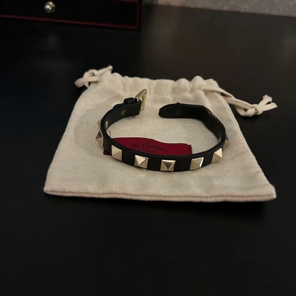 Snyggt svart armband från Valentino med coola silverfärgade nitar. Perfekt för att ge din outfit en edgy touch. Passar både till vardags och fest!. Accessoarer.