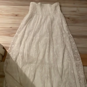 Vit långkjol från Gina Tricot - Superfin vit långkjol från Gina Tricot i storlek 146/152. Kjolen har en elastisk midja för extra komfort och ett vackert mönster som ger en romantisk känsla. Perfekt för sommarens alla äventyr eller en mysig vårdag. 🕊️