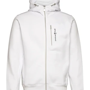 Vit hoodie från Sail Racing - Säljer en snygg vit hoodie från Sail Racing i mycket bra skick. Den har en dragkedja framtill och en praktisk bröstficka med dragkedja. Perfekt för både vardag och sportiga aktiviteter. Storleken är normal och den är långärmad med en bekväm passform.
