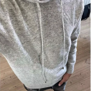 Grå merinoull hoodie - Säljer en stilren och bekväm grå merinoull hoodie. Den är helt ny och har aldrig använt den då jag råkade beställa fel storlek. Tröjan är i storlek S men passar även XS. Skriv till mig för mer info