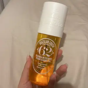 En superhärlig body mist från Sol de Janeiro med doft av pistage och saltad karamell. Flaskan är i en snygg orange färg med en vit kork och har en tropisk vibe. Perfekt för att känna sig som på en solig strand i Brasilien! 🌞 Mer än halfa flaskan finns kvar :)