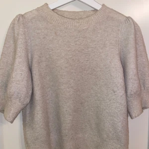 Beige stickad tröja från Vero Moda - Säljer en superfin beige stickad tröja från Vero Moda i storlek XS. Den har korta ärmar och en ribbad rund halsringning. Perfekt för både höst och vår, och den är i mycket bra skick. Passar till både jeans och kjol! Pris kan diskuteras.