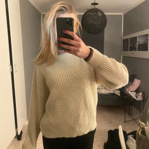 Beige stickad tröja - Säljer en supermysig beige stickad tröja med långärmad design. Perfekt för kyliga höst- och vinterdagar. Den har en skön passform och är i bra skick. Perfekt att matcha med jeans eller leggings för en avslappnad look.