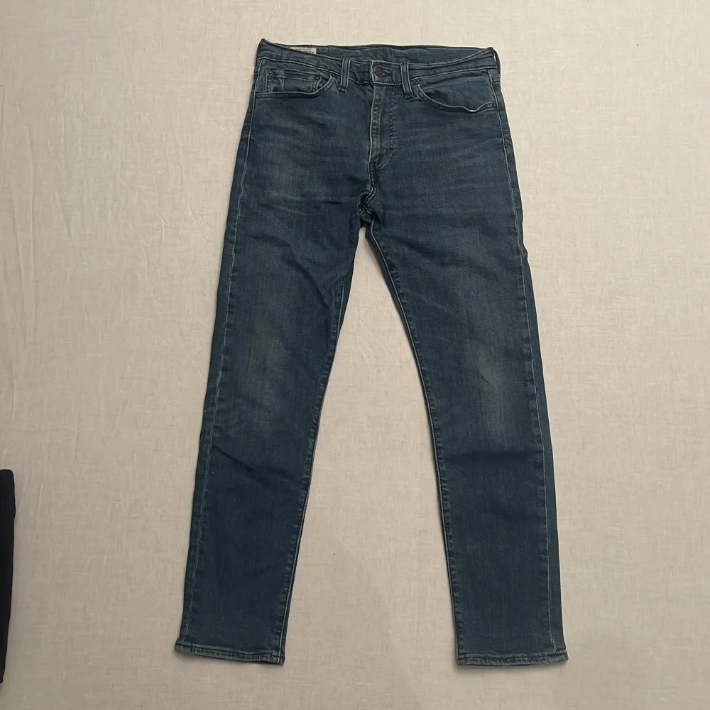 Säljer ett par snygga Levi's Premium jeans i blå denim. De har en klassisk femficksdesign och en bekväm passform. Perfekta för både vardag och fest! Bra skick förutom taggen som blivit sliten från tvätten (bild 4). Sitter slim/skinny och är strl. W32 L32 . Jeans & Byxor.