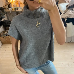 Grå stickad polotröja - Säljer en supermysig grå stickad polotröja med korta ärmar. Perfekt för höst och vår när du vill vara både stilren och bekväm. Tröjan har en ribbad polokrage och nederkant som ger en snygg detalj❤️❤️