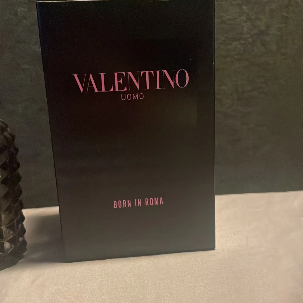 Säljer en lyxig Valentino Uomo Born in Roma Eau de Toilette. Flaskan är svart med ett coolt nitat mönster och rymmer 100 ml. Perfekt för den som vill ha en elegant och modern doft. Kommer i en snygg svart kartong. Perfekt present eller för att unna sig själv! 🌟. Parfym.