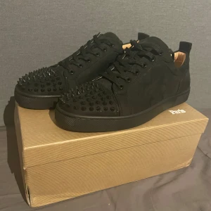 Helt nya Loubs - Säljer ett par svarta sneakers från Christian Louboutin helt nya. Skorna har svarta nitar på ovansidan och den ikoniska röda sulan. Perfekta för att ge din outfit en edgy touch! Allt som syns på bilderna medföljer! Inga returer.