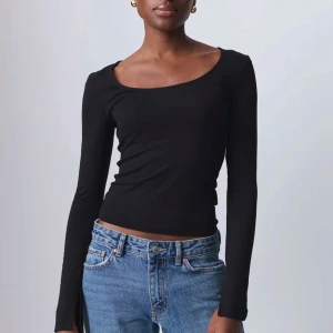 Svart långärmad topp - Snygg svart långärmad topp med en rundad halsringning. Perfekt för en stilren look och kan enkelt matchas med olika outfits. Helt ny
