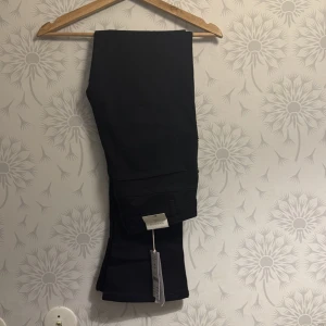 Svarta byxor  - Snygga svarta byxor med en stilren design. Perfekta för en elegant look. De har en rak passform och är tillverkade i ett bekvämt material.