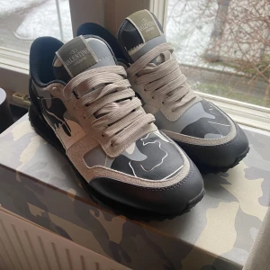 Valentino rockrunners - Snygga Valentino sneakers med grått och svart kamouflagemönster. Skorna har snörning och en stilren design med en mix av material som ger en unik look. Perfekta för dig som vill sticka ut med stil. 10/10 skick 