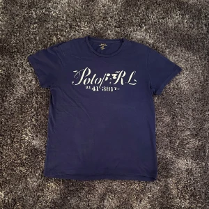 Polo Ralph Lauren t-shirt - Säljer min Polo R.L t-shirt i grymt skick. Riktigt schysst blå färg med ett chill tryck på framsidan. Har använt den enstaka gånger, dm för frågor!