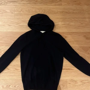 Mörkblå cashmere hoodie från Sayless - Säljer en stilren hoodie från Sayless i mjuk cashmere. Perfekt för kyliga dagar med sin bekväma passform. Ett måste i garderoben för den som älskar komfort och stil. Är 173 så passar som bäst till dom som är 165-170.