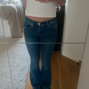 Blå low flare jeans - Snygga blå low flare jeans med låg midja från Bikbok. Väldigt stretchiga och väldigt bra skick. Längd 31