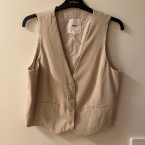 Beige väst från Object - Snygg beige väst från Object med knappar framtill och v-ringad design. 