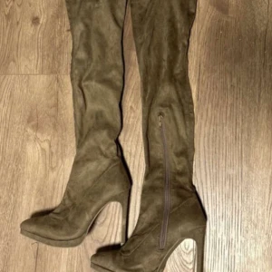 Bruna overknee boots med klack - Snygga bruna overknee boots i mocka med hög klack och dragkedja på sidan.  Aldrig använda