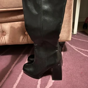 Svarta stövlar från Bershka - Snygga svarta stövlar från Bershka med hög klack och dragkedja på sidan. Perfekta för att ge en elegant touch till din outfit.