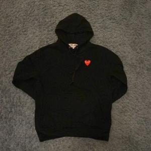 CDG hoodie - Säljer en stilren svart hoodie från Comme des Garçons. Storlek S men sitter smalt runt midjan. Den är däremot inte ”autentisk”