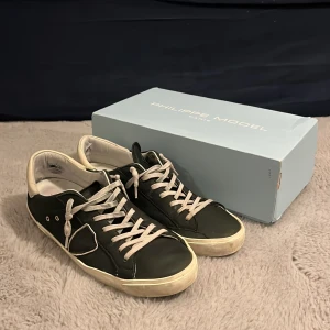 Philippe Model PRSX - Hej! Säljer nu dessa sjyssta Modelsen i storlek 44. Ett par sköna sneakers i färgen mörkgrön som passar till det mesta både finklätt och mer casual. Finns lite defekter på skorna men även lite på lådan då den blev dåligt behandlad av PostNord men inget särskilt märkvärdigt. Philippe Model certifikat medföljer. Köpta för 3200 mitt pris 1599. Vill du ha fler bilder så är det bara att fråga men även om det är något annat du undrar. Priset går att diskutera, inte fast hugget i en sten