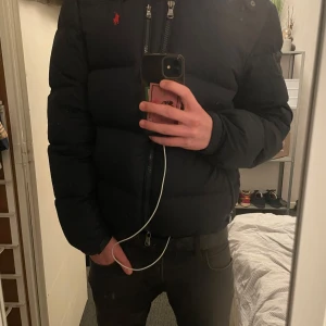 Ralph Lauren jacka - Säljer en svart/mörkblå jacka från Ralph Lauren med röd logga. Jackan har några tidigare hål som nu är lagade(syns knappt när den är på), kom privat för bilder, därav priset. Hör av dig vid intresse! 🚀