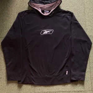 Svart hoodie från Reebok - Säljer en svart hoodie från Reebok med vit logga på bröstet. Hoodien har en luva med vit meshfoder och långa ärmar. Perfekt för en sportig look eller avslappnad stil. 🖤