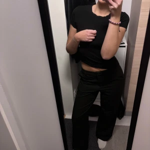 Svarta kostymbyxor från Lisa & Lena - Snygga svarta kostymbyxor från Lisa & Lena för NA-KD. Byxorna har en elegant design med hög midja och raka ben, perfekta för en stilren look. De är tillverkade i ett bekvämt material som ger en skön passform.