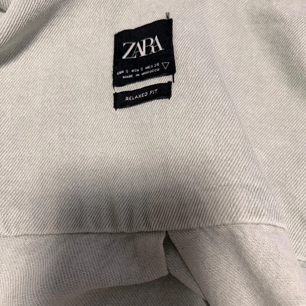 Säljer en stilren grå overshirt från zara Perfekt för lager-på-lager under hösten. Den har långa ärmar och knappar framtill samt två praktiska bröstfickor. Skön och avslappnad passform som funkar till det mesta. 🖤. Jackor.