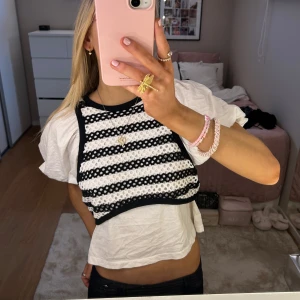 Randig topp med puffärmar - Säljer en superfin topp med puffiga kortärmar och ett randigt mönster i svart och vitt. Toppen har en unik design med en overlay som ger en cool lager-på-lager-look. Från zara, storlek S 💕