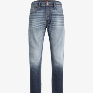 Blå jeansbyxor med tvättad effekt - Snygga blå jeansbyxor med en cool tvättad effekt som ger en avslappnad look. De har en klassisk femficksdesign och knappgylf. Perfekta för både vardag och fest! Uppsprättade vid sömmen längst ner så dem är inte längre. Knappt använda väldigt bra skick