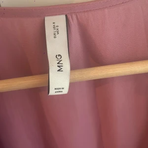 Lila omlottklänning från MNG - Rosa/lila omlottklänning från MNG i storlek L. V-ringad design och trekvartsärmar. Aldrig använt.