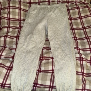 Grå mjukisbyxor från Divided - Säljer ett par superbekväma grå mjukisbyxor från Divided i storlek M. Perfekta för chill dagar hemma eller en snabb tur till affären. De har en elastisk midja med snörning för bästa passform. Materialet är mjukt och skönt, perfekt för höst och vinter. 🩶