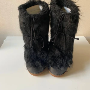 Svarta pälsboots från Frenzy - Säljer ett par unika svarta boots från Frenzy i storlek41- 42. De är täckta med fluffig päls och har en robust sula för bra grepp. Perfekta för vinterns kalla dagar. Skorna har snörning framtill för en säker passform.