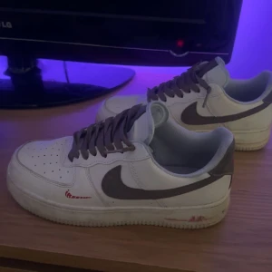 Nike Air Force i vitt och grått - Säljer ett par klassiska Nike Air Force sneakers i vitt med grå detaljer. De har en snygg och tidlös design med snörning och är perfekta för vardagsbruk. Skorna är i bra skick med lite slitage på sulan. Perfekta för både vår och höst!