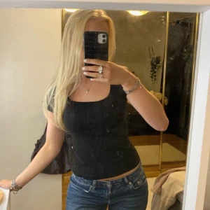 Svart tight topp - Säljer en svart tight topp i mycket bra skick. Den har en enkel design med korta ärmar och en rund halsringning. Perfekt för både vardag och fest!har små ”noppror” INUTI tröjan från tvättmaskin, som inte syns när man har den på sig. går att få bort med hårroller men har endast tagit på utsidan då de int känns nödvändigt inuti, syns på sista bilden🎨🍒