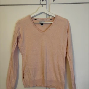 Ljusrosa V-ringad tröja - Säljer en ljusrosa V-ringad tröja i bra skick. Den är perfekt för både vår och höst med sin mjuka och bekväma passform. Tröjan har långa ärmar och ribbade kanter som ger en stilren look. Passar perfekt till jeans eller kjol för en avslappnad stil. 🌸