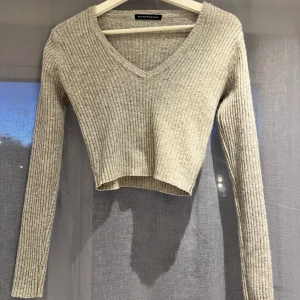 Långärmad tröja - Grå, långärmad tröja som är lite stickad/ribbad. Från Brandy Melville så den är onesize men passar mig bra som har storlek S! Använd gärna köp nu 💕