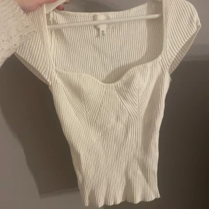 Vit ribbad topp från H&M - Säljer en superfin vit ribbad topp från H&M. Perfekt för både vardag och fest! 55+ frakt