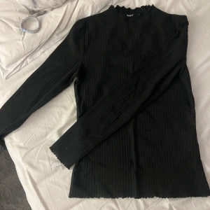 Svart ribbad tröja från ONLY - Säljer en stilren svart ribbad tröja från ONLY i storlek S. Tröjan har långa ärmar och en enkel design som passar perfekt till både vardag och fest. Den är i mycket bra skick och redo för en ny ägare!