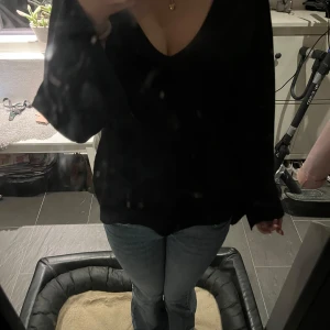 Svart v-ringad stickadtröja - Säljer en stilren svart tröja med v-ringning. Den har långa ärmar och är perfekt för både vardag och fest. Tröjan är i bra skick och passar till det mesta i garderoben. Perfekt för höst och vinter!