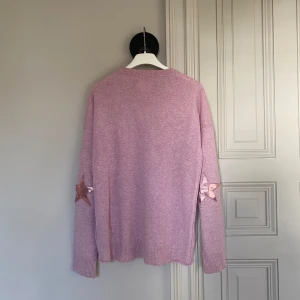 Rosa Zadig tröja stjärnor - Säljer en söt rosa stickad tröja från Zadig et Voltaire i modellen Cissi Patch. Den är L men sitter som en M.