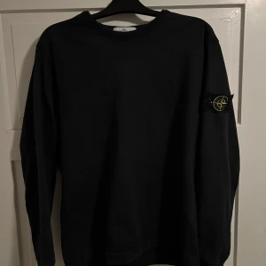 Svart tröja från Stone Island Strl L - Säljer en svart långärmad tröja från Stone Island, Tröjan är i storleken L och passar dig som även har M. Tröjan är i skick 9/10 finns inga flaws eller liknande. Enbart använd ett fåtal gånger.