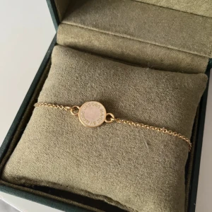 Marc by Marc Jacobs guld armband - Elegant guldarmband med en rund berlock som har ingraverad Marc by Marco Jacobs. Armbandet har en tunn kedja och en säker låsning. Perfekt för att ge en stilren touch till din outfit💞💞